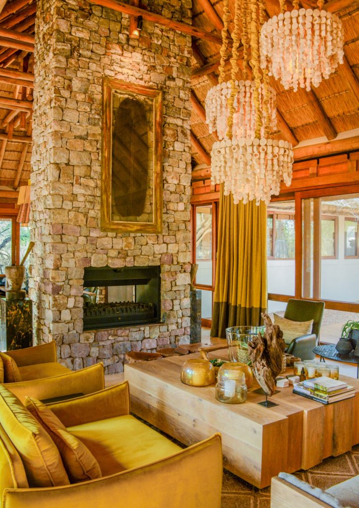 Madikwe, Living room, Indoor fireplace, Coffee table, Armchair, Hanging lights